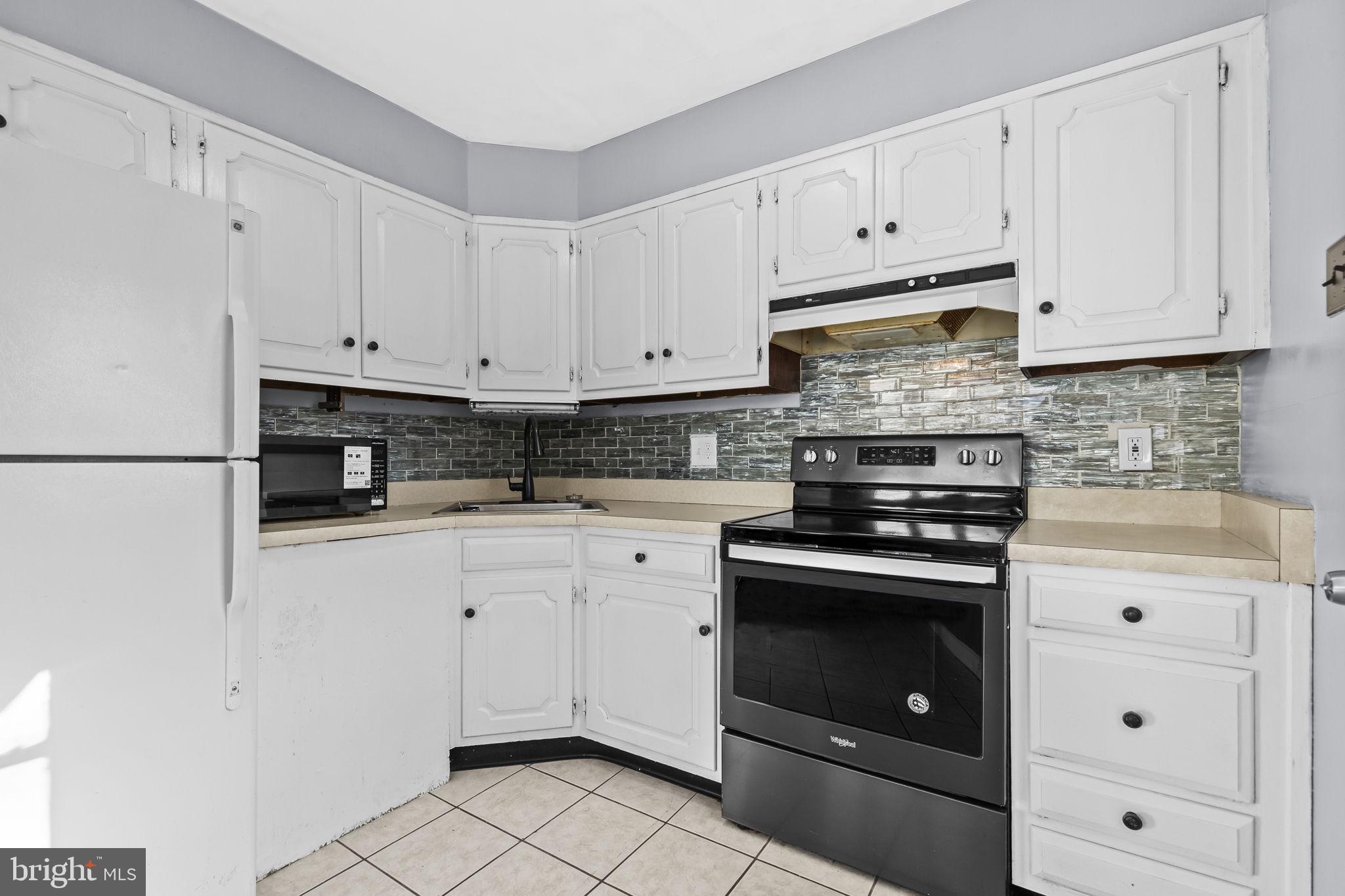 3407 Orbitan Road Parkville, MD 21234 - Photo 15 of 23 a kitchen with granite countertop white cabinets and stainless steel appliances