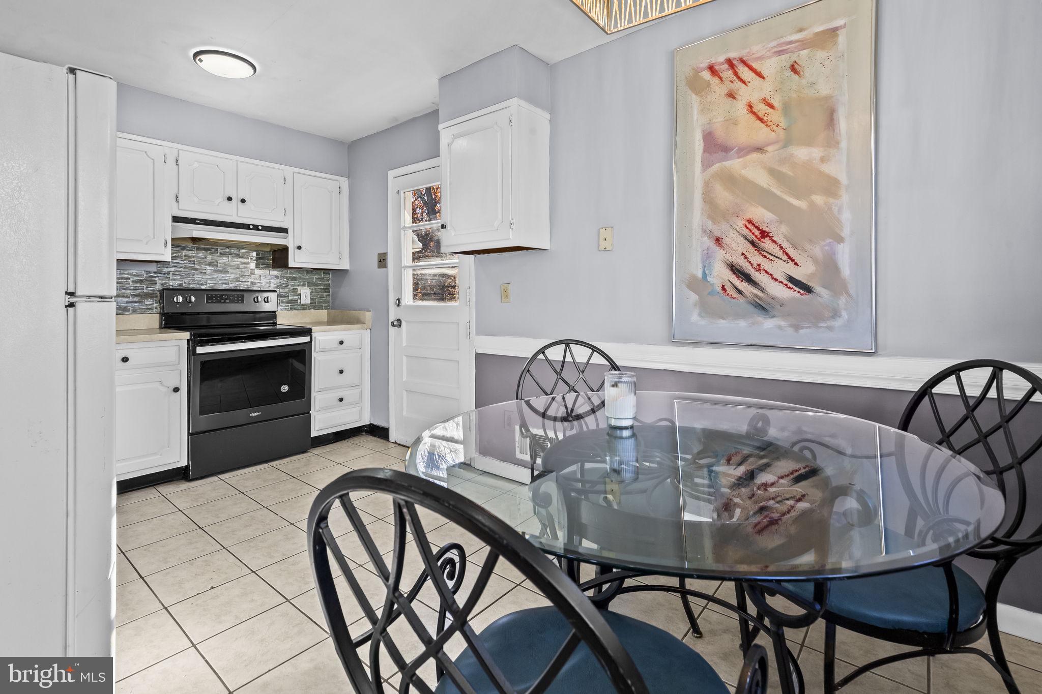 3407 Orbitan Road Parkville, MD 21234 - Photo 16 of 23 a kitchen with stainless steel appliances granite countertop a dining table and chairs with wooden floor