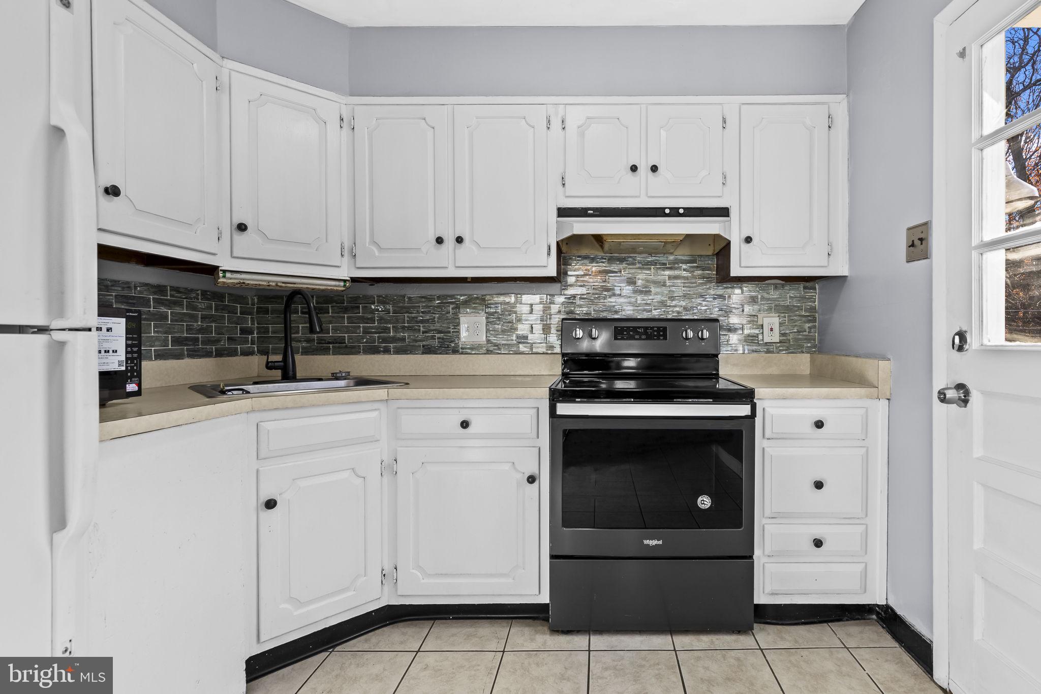 3407 Orbitan Road Parkville, MD 21234 - Photo 3 of 23 a kitchen with white cabinets and stainless steel appliances