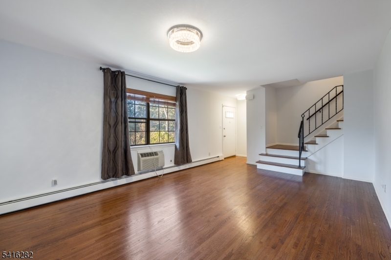 768 Springfield Avenue, Unit E4 Summit, NJ 07901 - Photo 11 of 28 a view of an empty room with wooden floor and a window