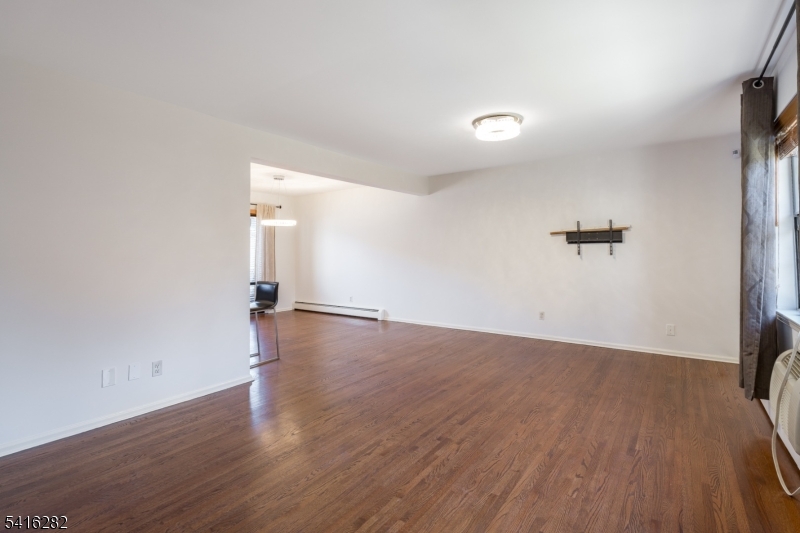 768 Springfield Avenue, Unit E4 Summit, NJ 07901 - Photo 12 of 28 an empty room with wooden floor and windows