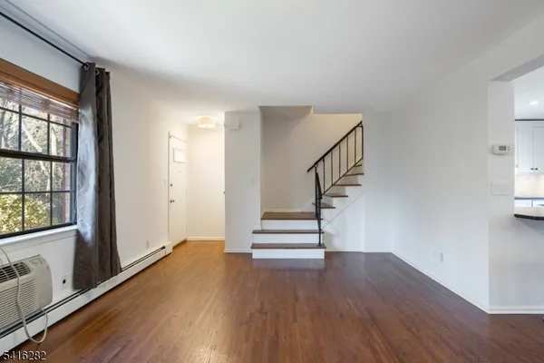 a view of entryway with wooden floor and stairs