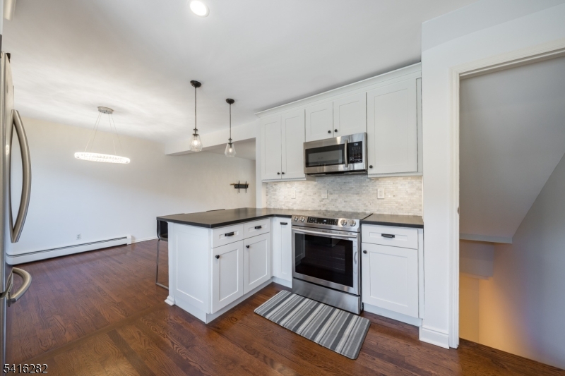 768 Springfield Avenue, Unit E4 Summit, NJ 07901 - Photo 6 of 28 a kitchen with stainless steel appliances granite countertop a stove a sink and a microwave