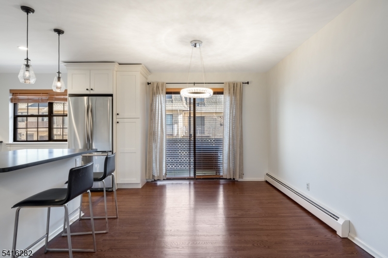 768 Springfield Avenue, Unit E4 Summit, NJ 07901 - Photo 9 of 28 an empty room with wooden floor and windows