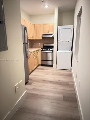 a kitchen with granite countertop a refrigerator and a sink