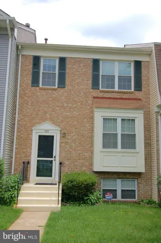 a view of backyard with potted plants and wooden fence