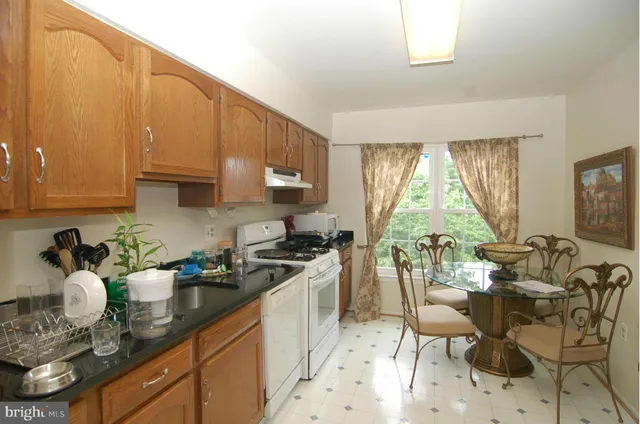 a kitchen with stainless steel appliances granite countertop a sink a stove and a wooden floors