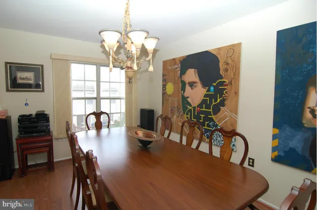 a view of a dining room with furniture a chandelier and wooden floor