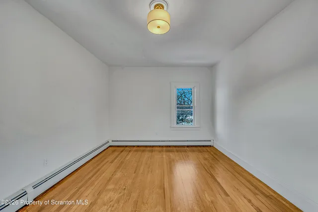 a view of room with window and wooden floor