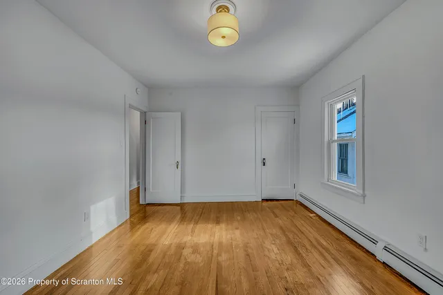 a view of a room with wooden floor and a window