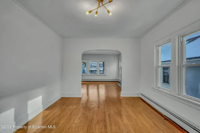 a view of a hallway with wooden floor and a cabinet