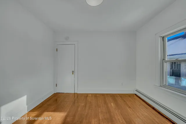 a view of a room with wooden floor and cabinet