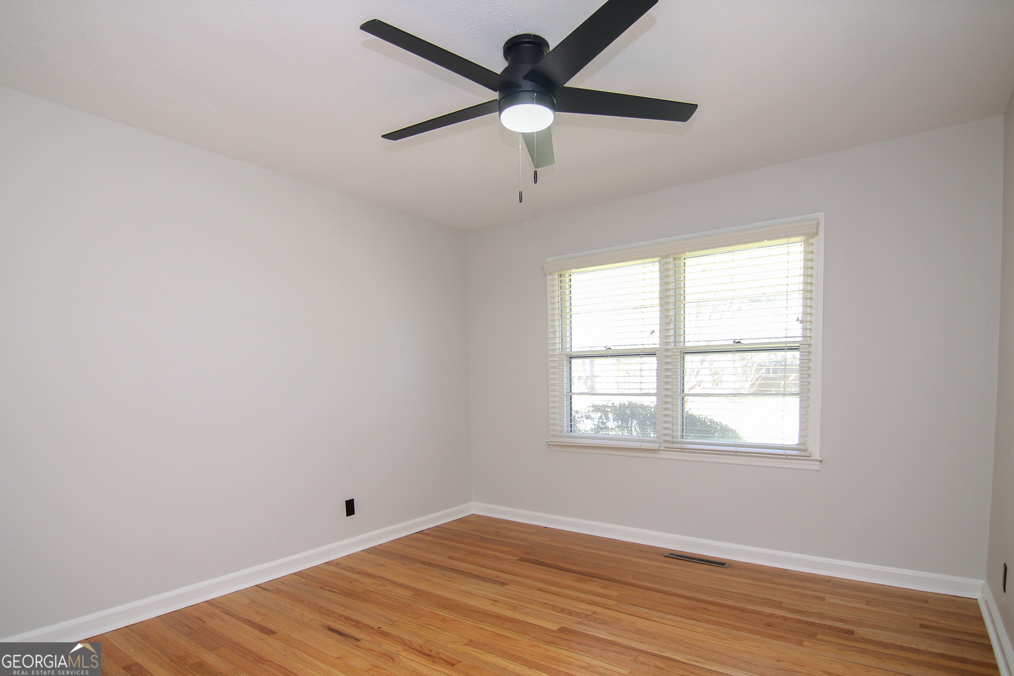 110 Springdale Drive Warner Robins, GA 31088 - Photo 12 of 25 an empty room with wooden floor ceiling fan and windows