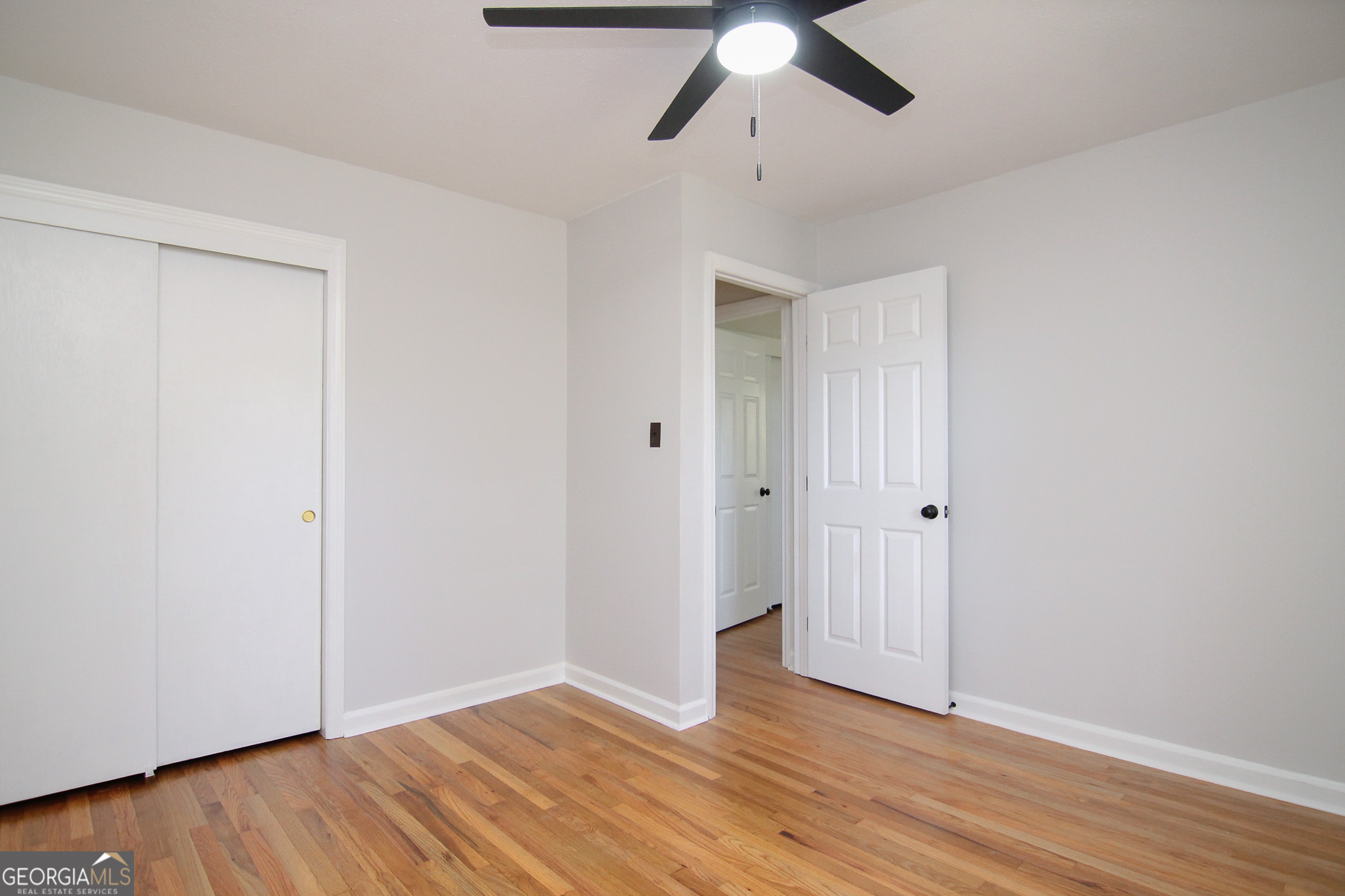 110 Springdale Drive Warner Robins, GA 31088 - Photo 19 of 25 an empty room with wooden floor chandelier fan and closet area