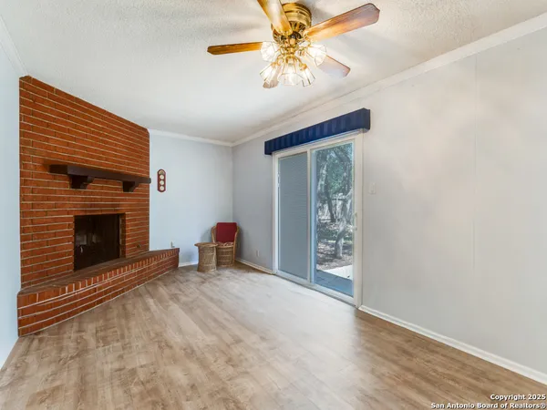 an empty room with windows and fireplace