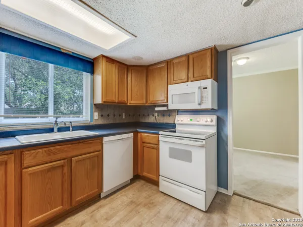 a kitchen with white cabinets and white appliances