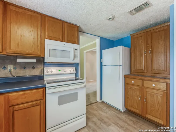 a kitchen with a stove refrigerator and cabinets