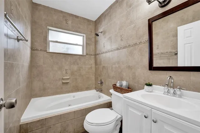 a bathroom with a sink a toilet a mirror and shower