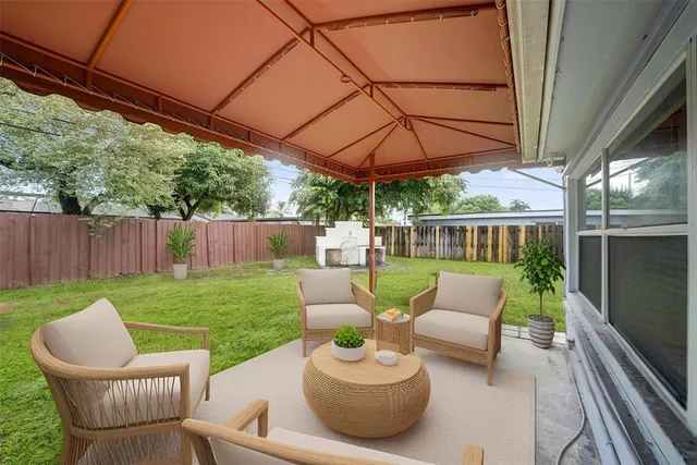 a view of a patio with couches chairs potted plants and a yard