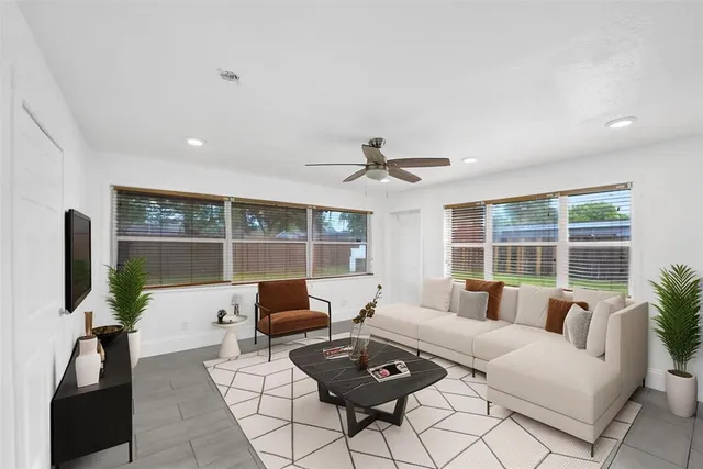 a living room with furniture and floor to ceiling windows