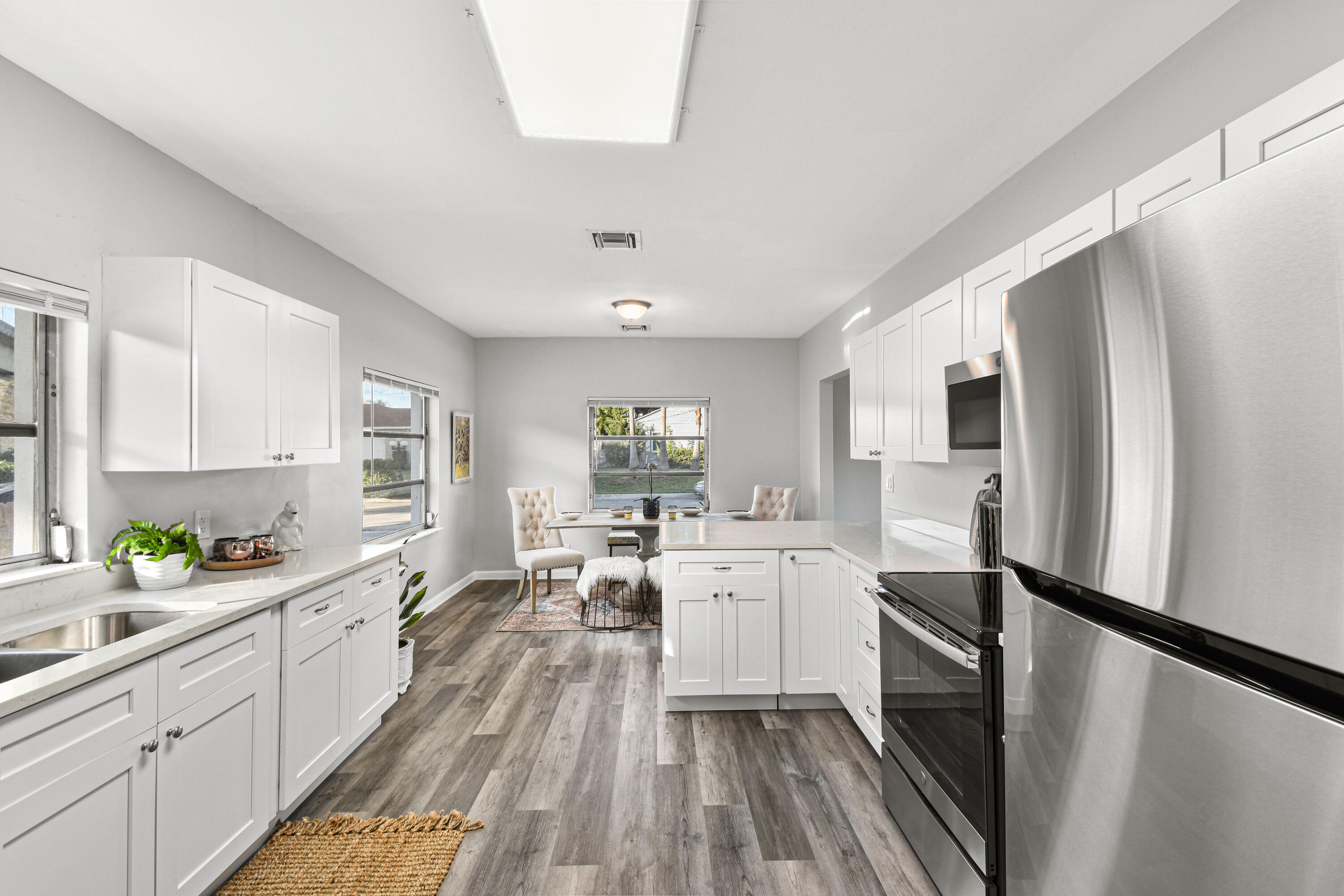 1102 Sunset Road West Palm Beach, FL 33401 - Photo 14 of 37 a kitchen with white cabinets and stainless steel appliances