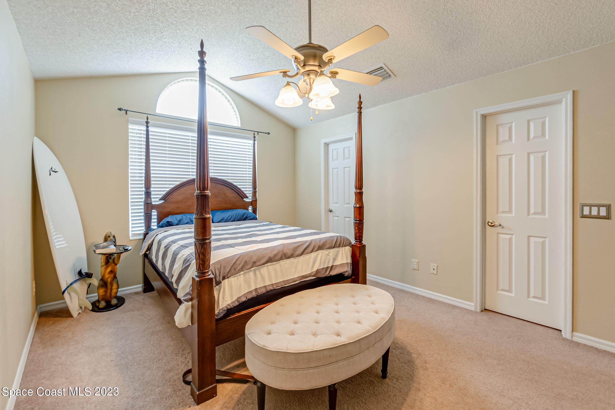 4540 Rivermist Drive Melbourne, FL 32935 - Photo 21 of 39 a bedroom with a bed and a chandelier