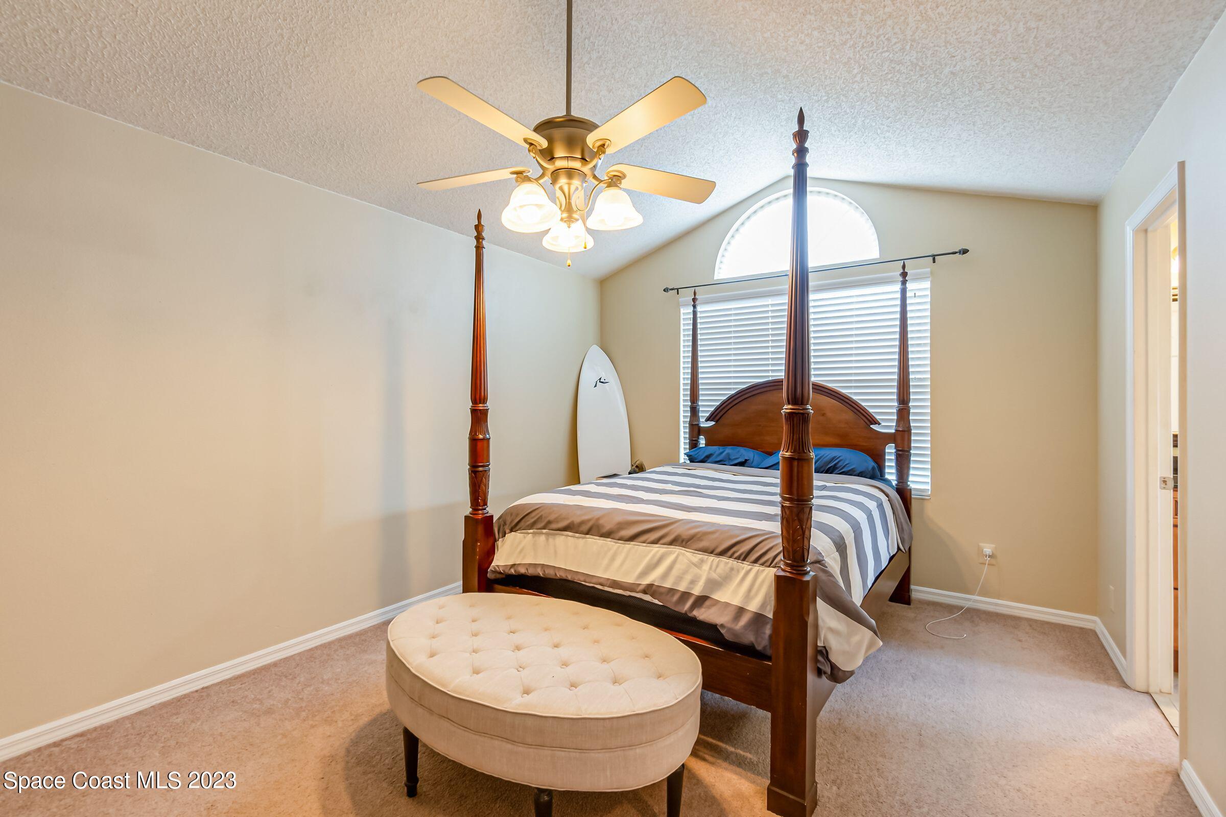 4540 Rivermist Drive Melbourne, FL 32935 - Photo 22 of 39 a bedroom with a bed and a chandelier