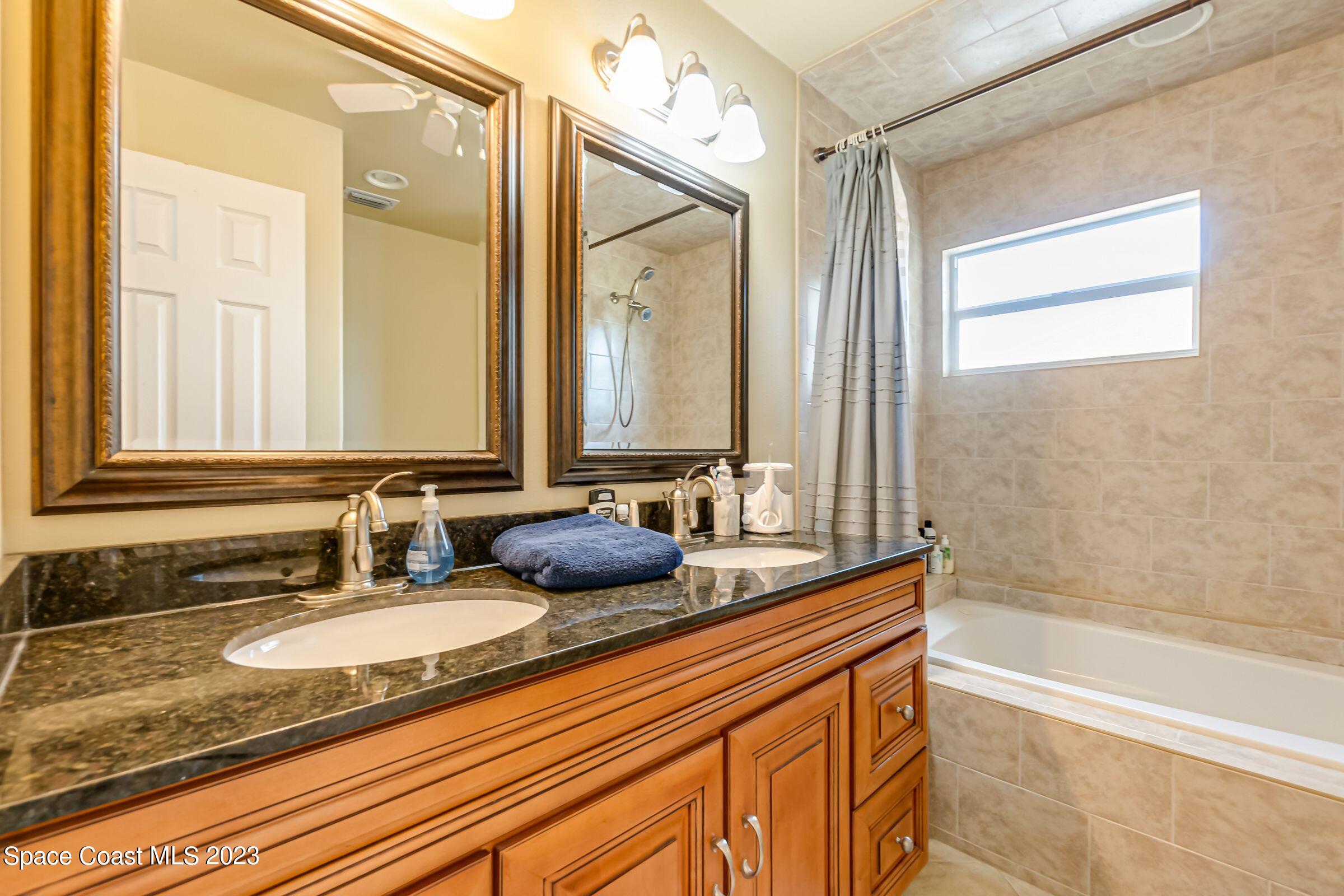 4540 Rivermist Drive Melbourne, FL 32935 - Photo 24 of 39 a bathroom with a granite countertop sink and a mirror