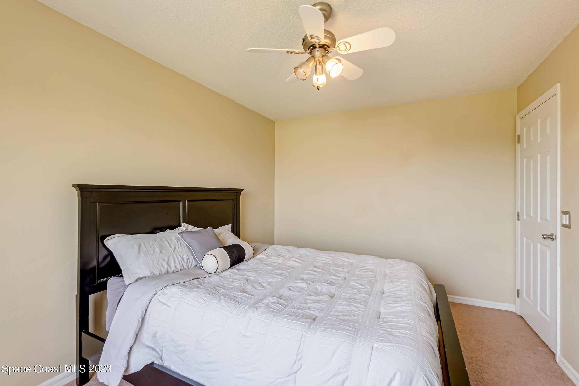 4540 Rivermist Drive Melbourne, FL 32935 - Photo 27 of 39 a bedroom with a bed and a chandelier