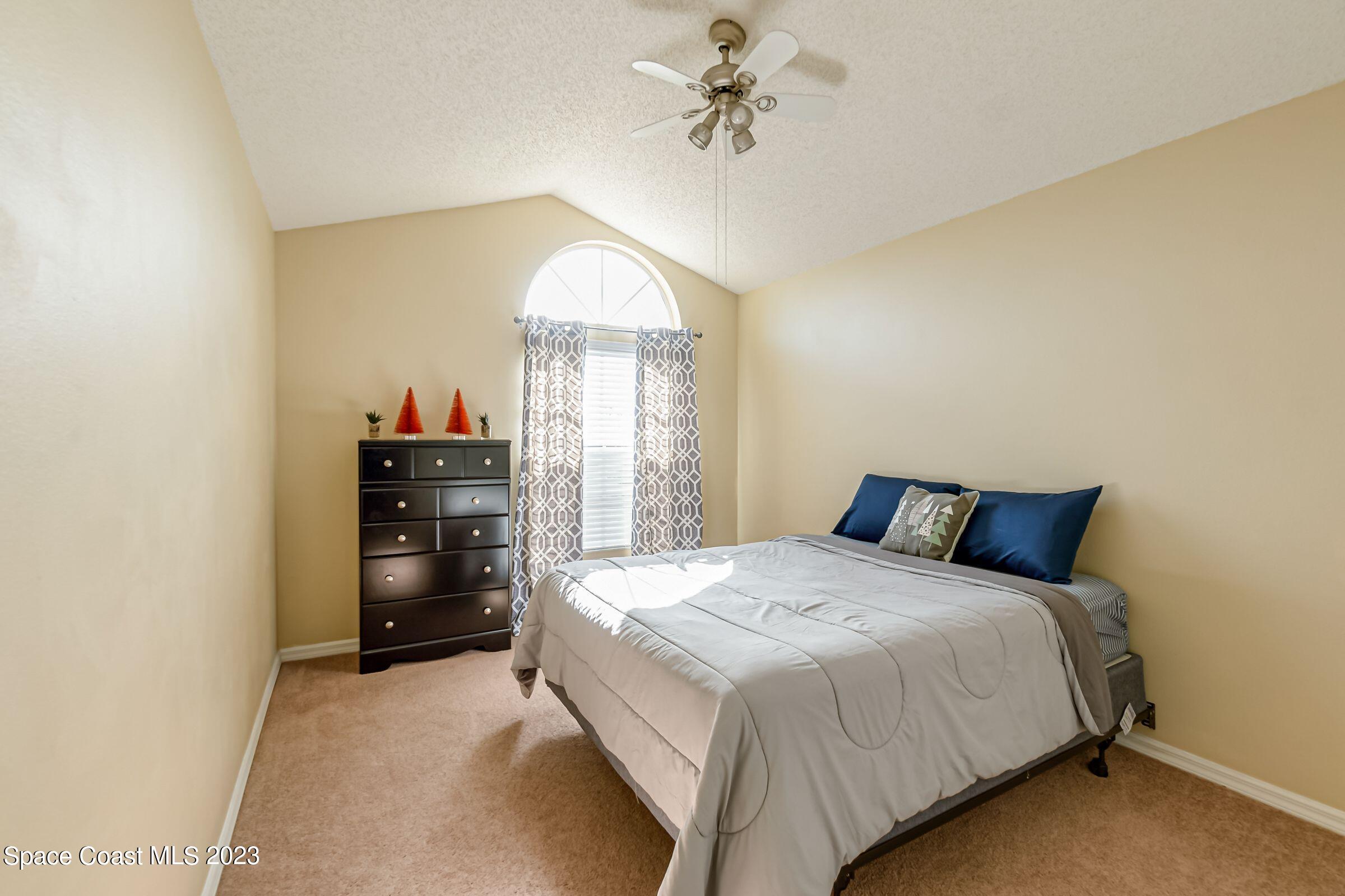 4540 Rivermist Drive Melbourne, FL 32935 - Photo 30 of 39 a bedroom with a bed and a chandelier
