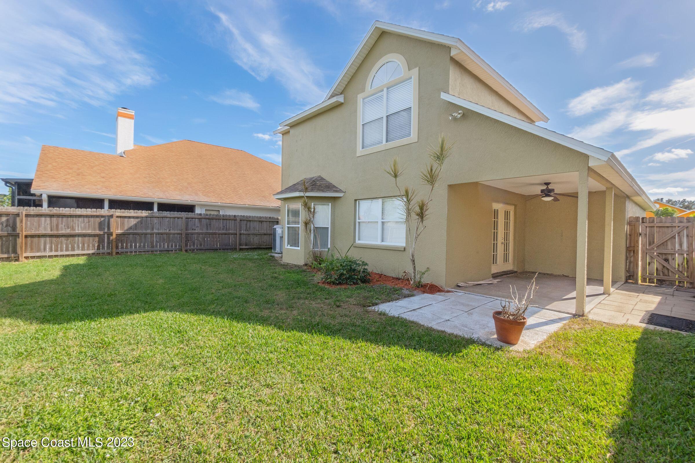 4540 Rivermist Drive Melbourne, FL 32935 - Photo 35 of 39 a backyard of a house with wooden floor table and chairs