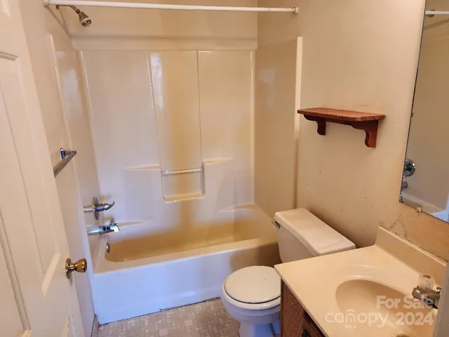 a white toilet sitting next to a bath tub