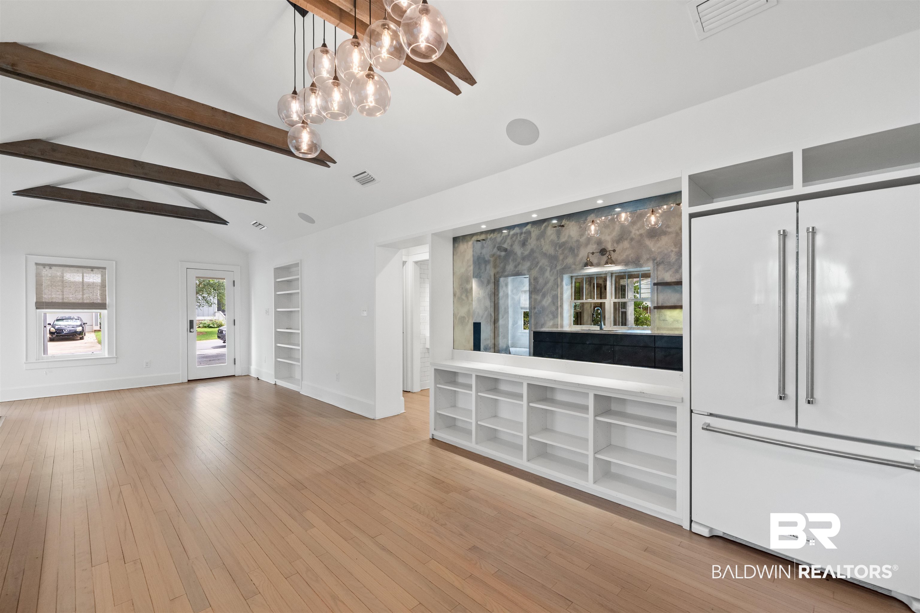 106 White Avenue Fairhope, AL 36532 - Photo 5 of 35 Unfurnished living room featuring built in shelves, a chandelier, and light wood-style flooring