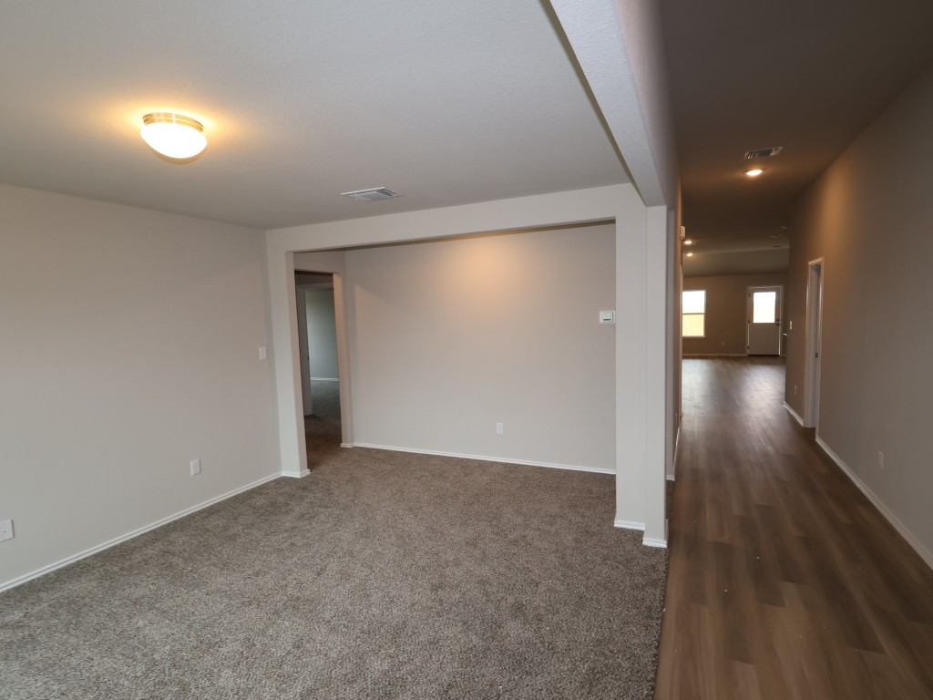 13709 Warnock Trail Manor, TX 78653 - Photo 13 of 25 an empty room with wooden floor and windows