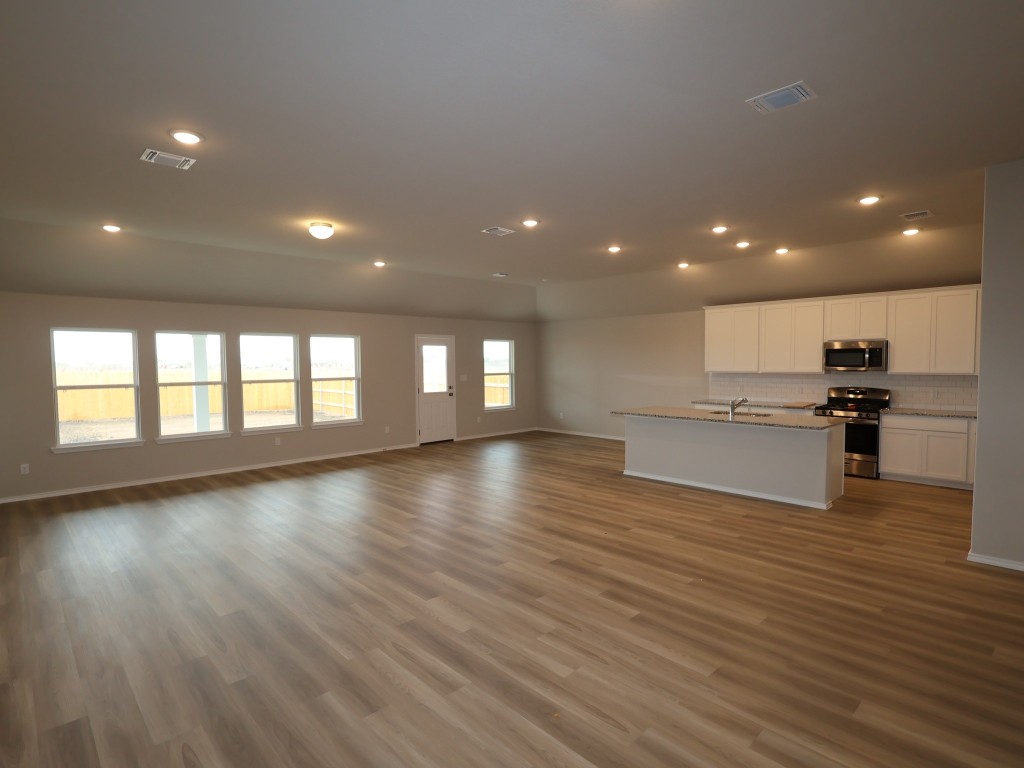 13709 Warnock Trail Manor, TX 78653 - Photo 5 of 25 a view of empty room with wooden floor and windows