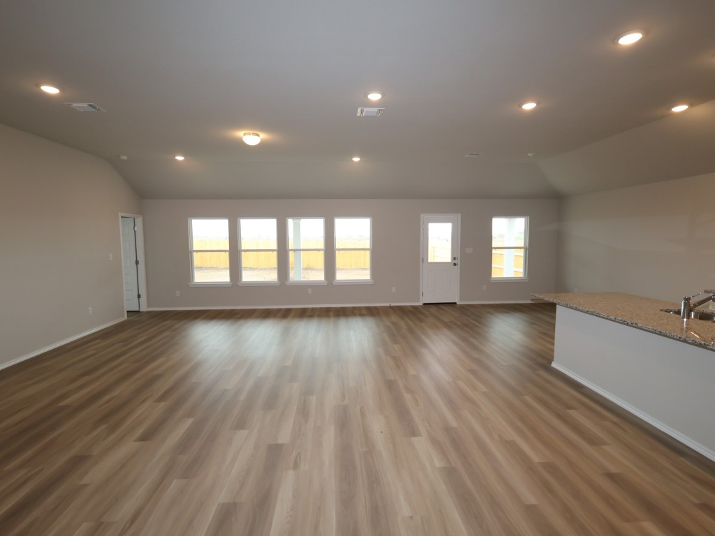 13709 Warnock Trail Manor, TX 78653 - Photo 6 of 25 a view of an empty room with wooden floor and a window