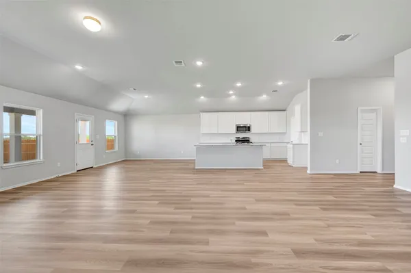 a view of empty room with wooden floor