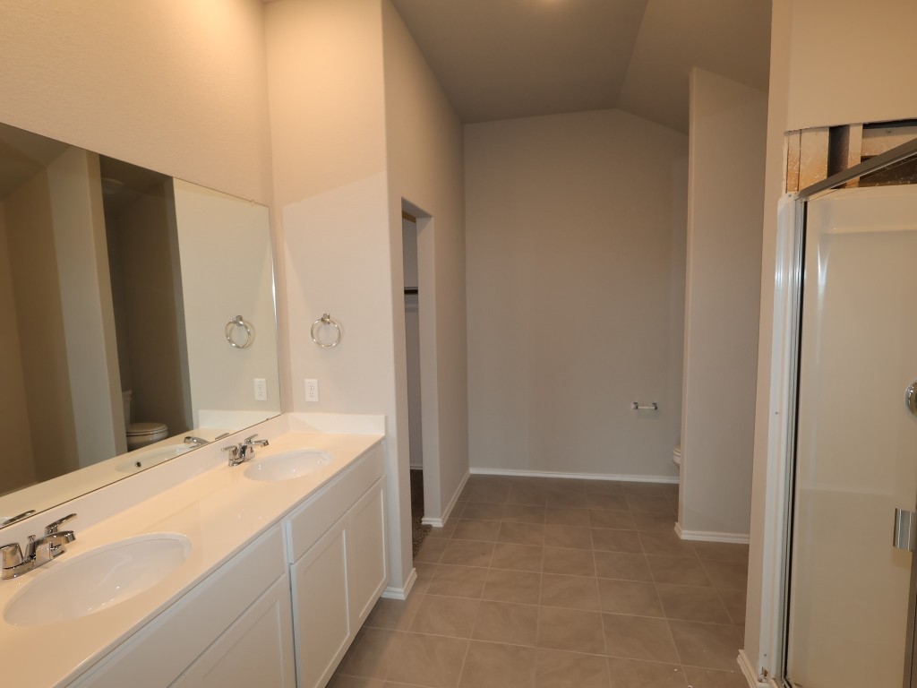 13709 Warnock Trail Manor, TX 78653 - Photo 10 of 25 a spacious bathroom with a double vanity sink and mirror