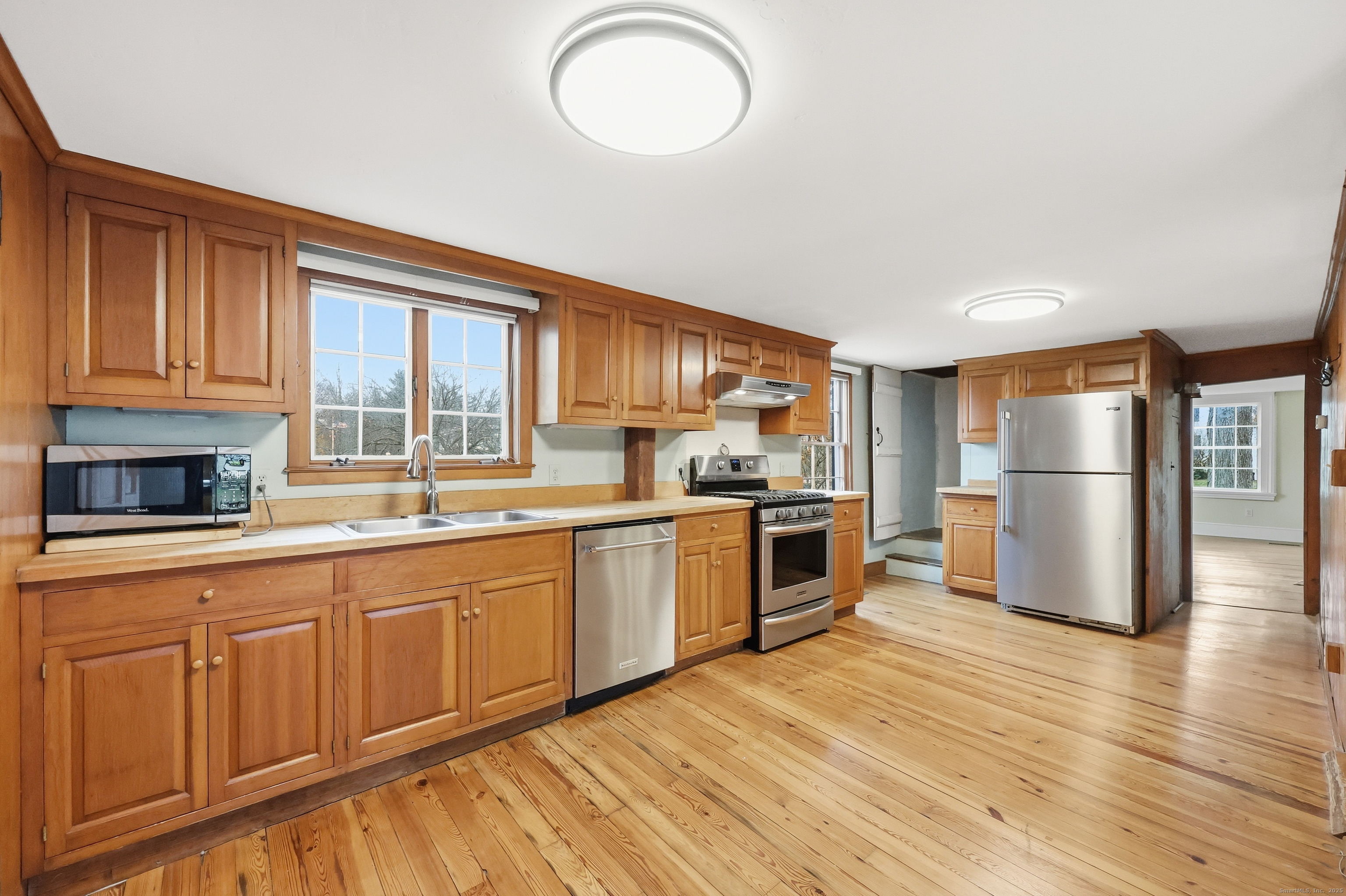 268 Main Street Durham, CT 06422 - Photo 12 of 40 a kitchen with granite countertop a refrigerator a stove top oven and wooden floors