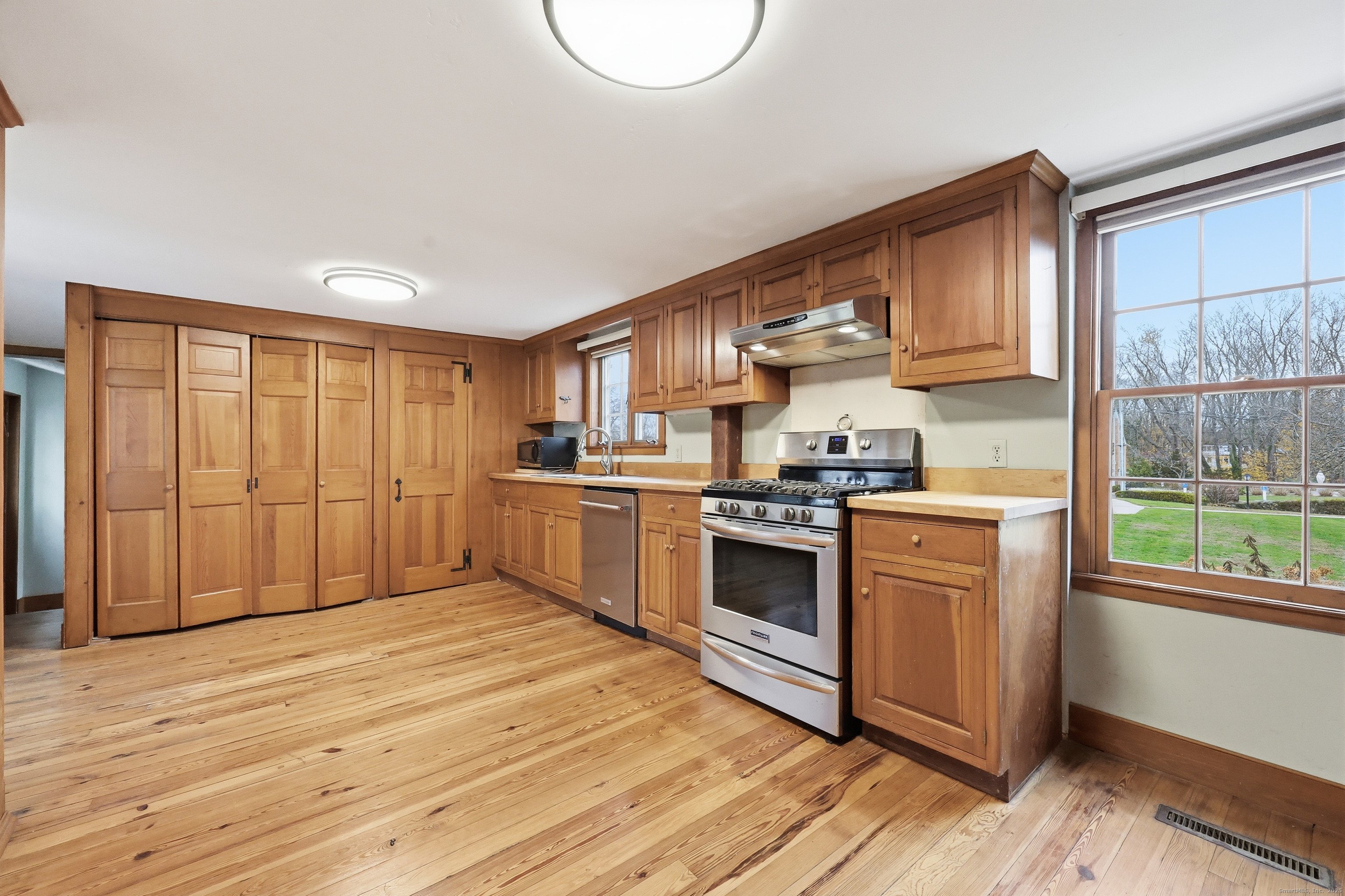 268 Main Street Durham, CT 06422 - Photo 14 of 40 a kitchen with stainless steel appliances granite countertop a stove a sink and a refrigerator with wooden floors