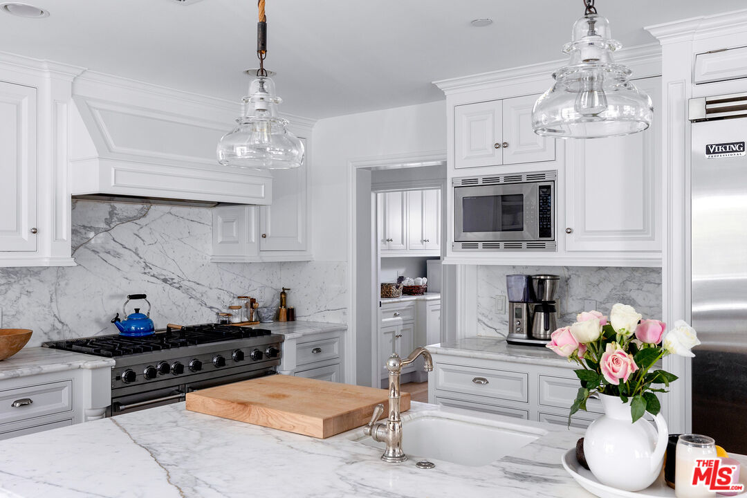 369 22nd Street Santa Monica, CA 90402 - Photo 8 of 29 a kitchen with stainless steel appliances kitchen island granite countertop stove top oven and cabinets