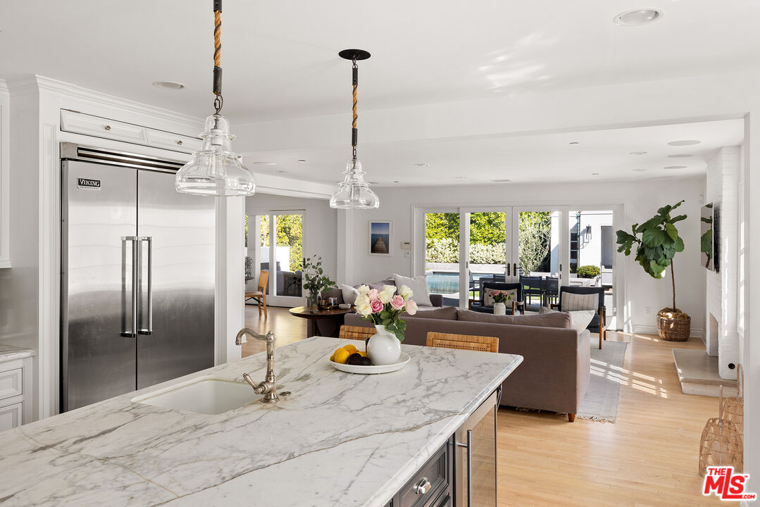 369 22nd Street Santa Monica, CA 90402 - Photo 10 of 29 a kitchen with stainless steel appliances granite countertop a refrigerator a oven a sink dishwasher and a dining table with wooden floor
