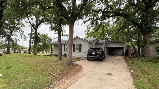 a car parked in front of a house with a yard