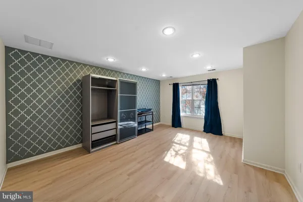 a view of empty room with wooden floor and window