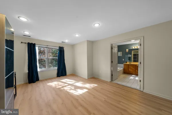 a view of hallway with wooden floor and a window