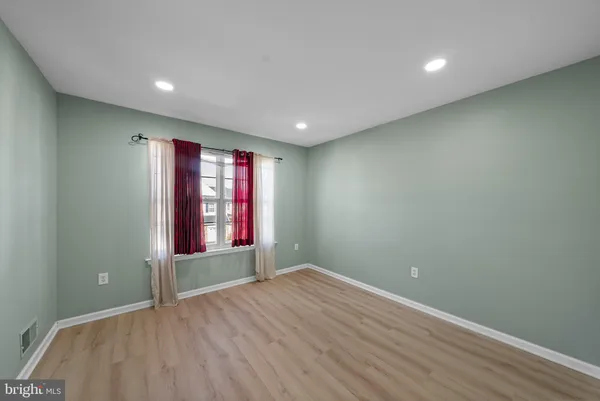 an empty room with wooden floor and window