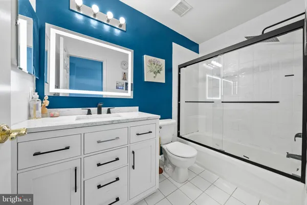 a bathroom with a double vanity sink mirror and toilet