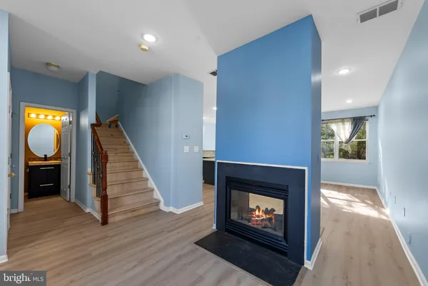 a living room with wooden floor and a fireplace