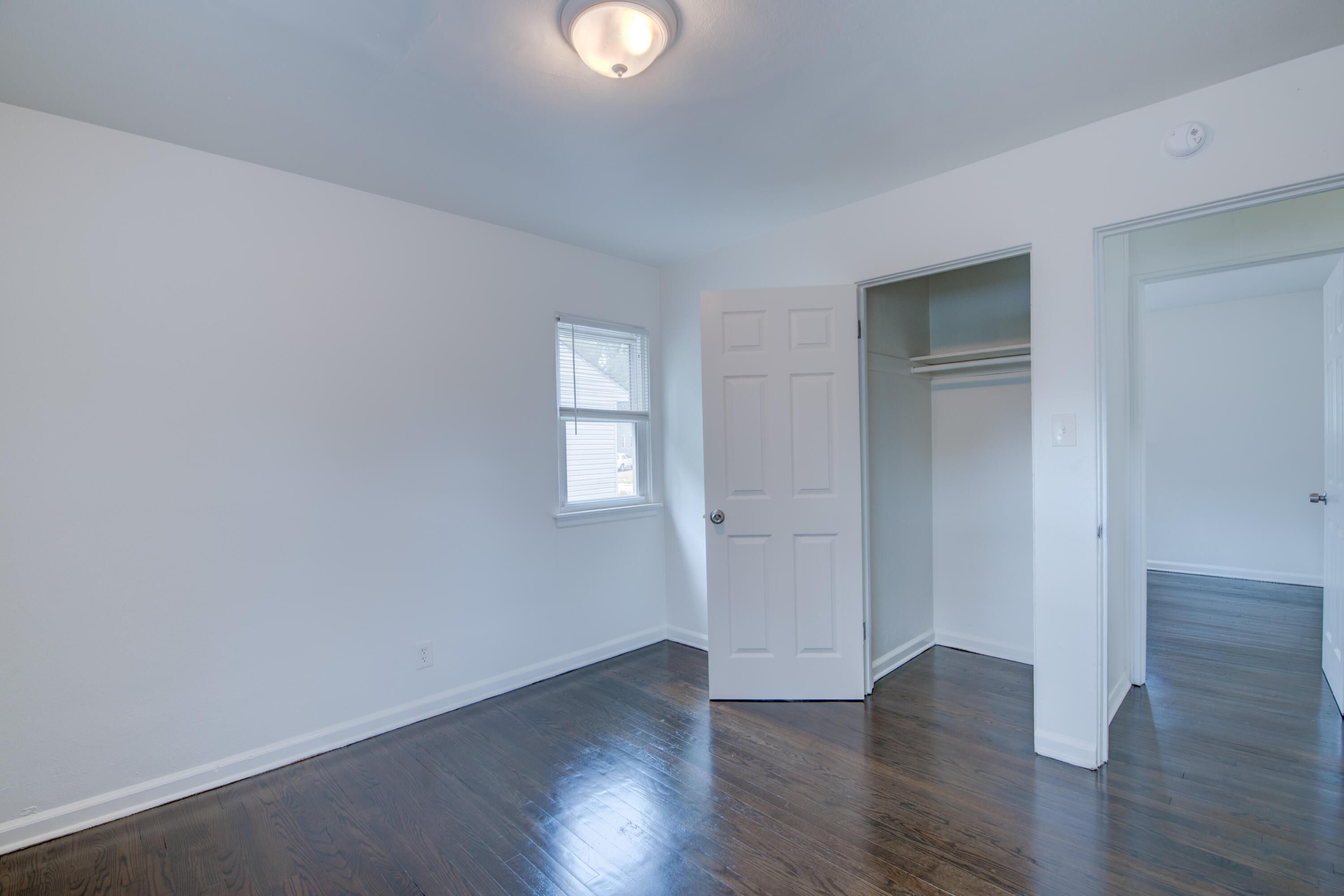 4409 East 11th Avenue Gary, IN 46403 - Photo 17 of 32 a view of an empty room with wooden floor and a window