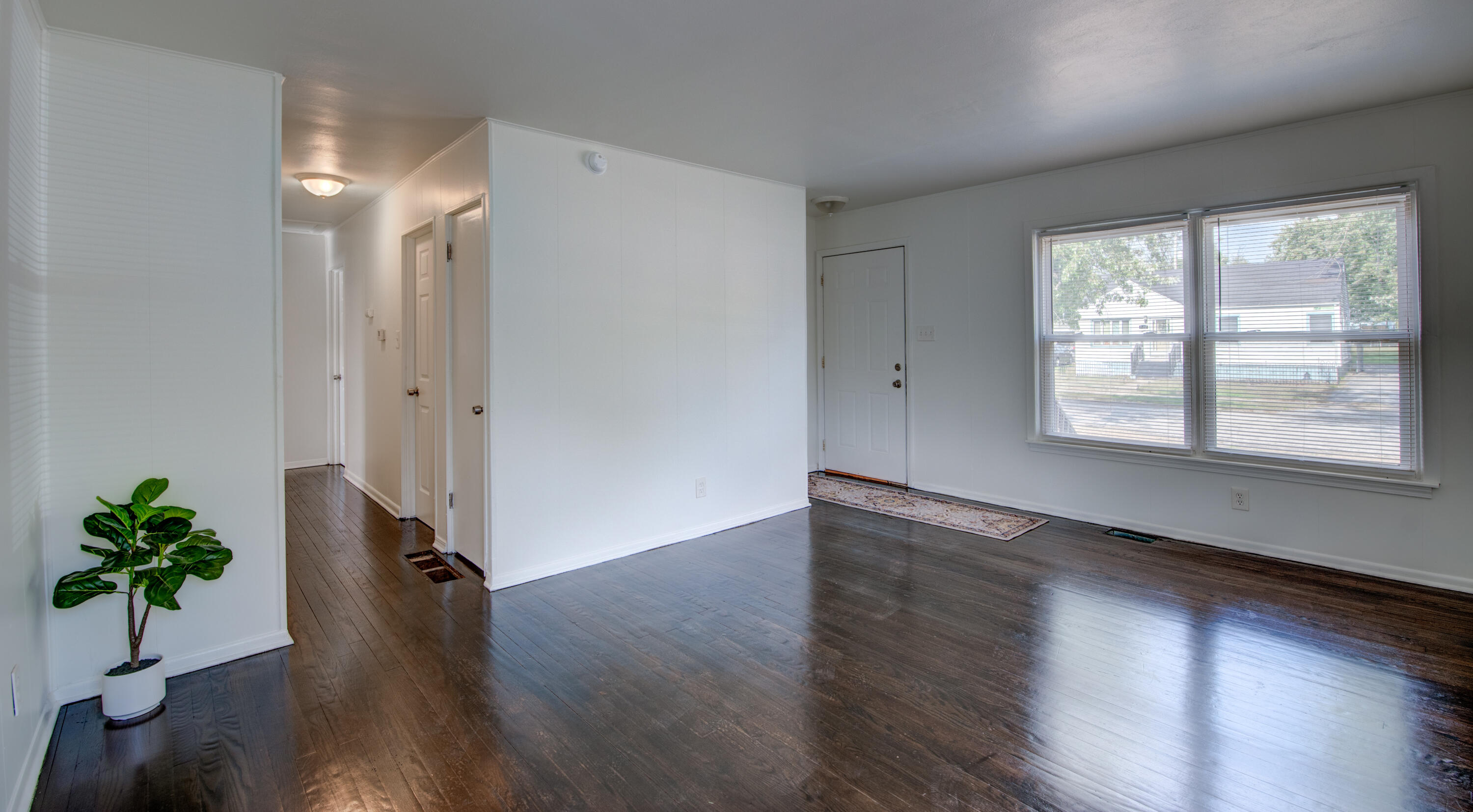 4409 East 11th Avenue Gary, IN 46403 - Photo 7 of 32 a view of an empty room with wooden floor and a window